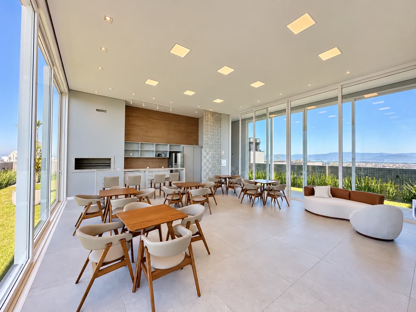 Espaço gourmet do rooftop com mesas e vista