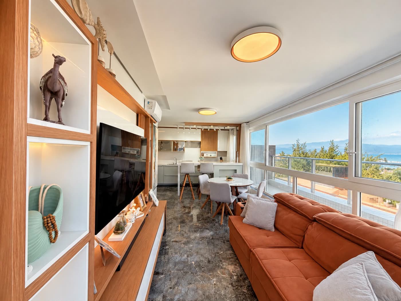 Living com sofá, TV e janelas amplas